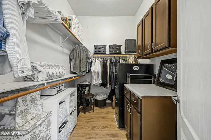 This walk-in closet includes cabinets and organized shelving.