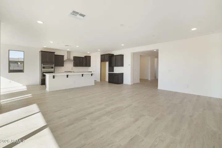 LARGE OPEN GREAT ROOM WITH A 16' SLIDER AND CONTINUOUS WOOD PLANK TILE THROUGHOUT THE GREAT ROOM.