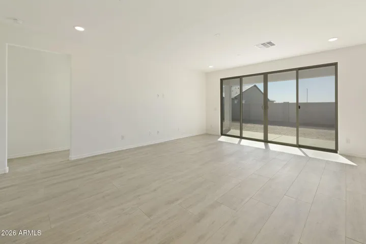 LARGE OPEN GREAT ROOM WITH A 16' SLIDER AND CONTINUOUS WOOD PLANK TILE THROUGHOUT THE GREAT ROOM.