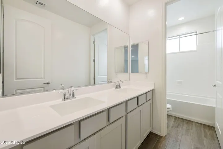 HALL BATH WITH DUAL VANITIES AND DOOR TO TUB/SHOWER AREA.