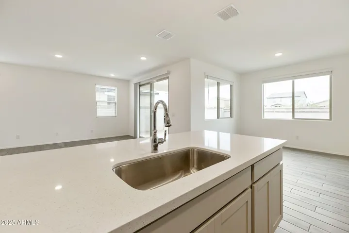 PAINTED CABINETS, QUARTZ COUNTERS, DESIGNER BACKSPLASH, STAINLESS STEEL APPLIANCES AND LARGE WALK IN PANTRY