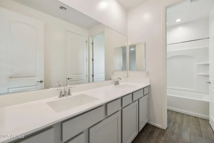 HALL BATH WITH DUAL VANITIES AND DOOR TO TUB/SHOWER AREA.