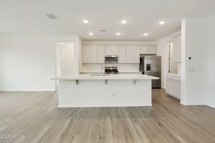 PAINTED CABINETS, QUARTZ COUNTERS, DESIGNER BACKSPLASH, STAINLESS STEEL APPLIANCES AND LARGE WALK IN PANTRY