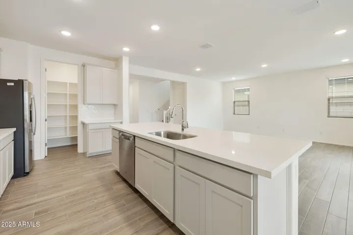 PAINTED CABINETS, QUARTZ COUNTERS, DESIGNER BACKSPLASH, STAINLESS STEEL APPLIANCES AND LARGE WALK IN PANTRY