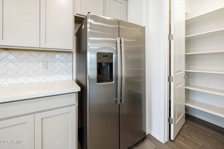 PAINTED CABINETS, QUARTZ COUNTERS, DESIGNER BACKSPLASH, STAINLESS STEEL APPLIANCES AND LARGE WALK IN PANTRY