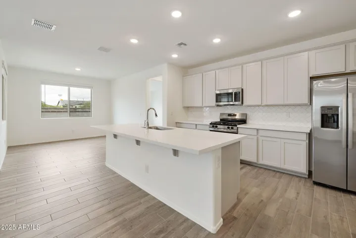 PAINTED CABINETS, QUARTZ COUNTERS, DESIGNER BACKSPLASH, STAINLESS STEEL APPLIANCES AND LARGE WALK IN PANTRY