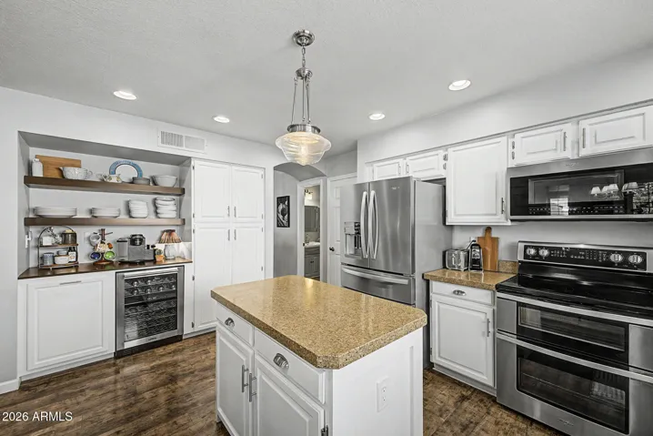 Stylish kitchen with built-in beverage fridge, stainless steel appliances, granite countertops. Designed for entertaining, this home kitchen blends convenience with modern upgrades.