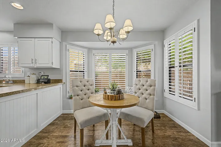 Cozy breakfast nook with abundant natural light and plantation shutters. Ideal for casual dining, this charming space sits adjacent to the upgraded kitchen in this Peoria home.