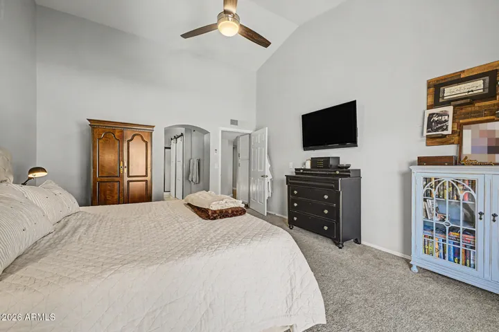 Generous primary suite with high ceilings, ceiling fan, and ample space for furnishings. This Peoria home offers a comfortable and airy bedroom layout.