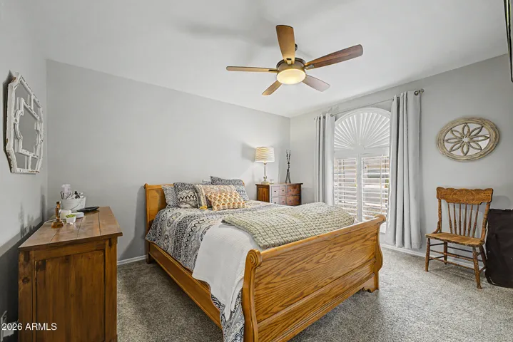 Comfortable secondary bedroom with natural light, ceiling fan, and neutral finishes. This versatile space is ideal for guests, office use, or additional living in this Peoria home.