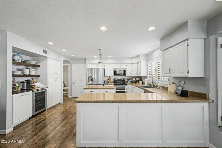 Bright upgraded kitchen featuring a large center island with seating, white cabinetry, and ample counter space.This offers modern finishes, recessed lighting, and an ideal layout for cooking and entertaining