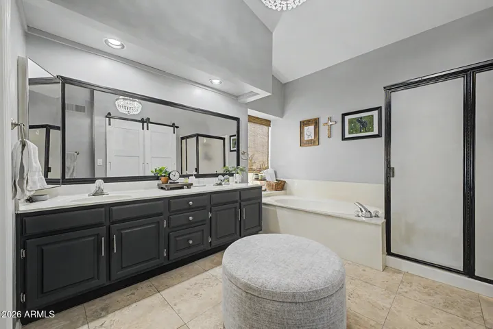 Spacious primary bathroom with dual vanities, soaking tub, and separate shower. Updated finishes and ample counter space create a spa-like experience in this Peoria home.