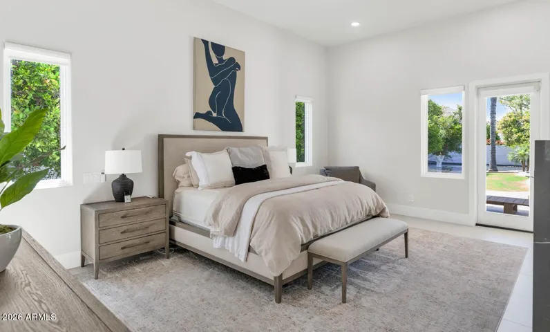 The primary suite extends beyond its generous interior through a private door that opens directly to a covered patio adjacent to the spa and pool. The indoor-outdoor connection here is effortless — stepping from bed to a quiet Arizona morning requires nothing more than a single step.
