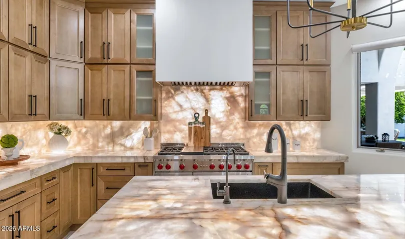 Cristallo stone countertops take center stage in this view, their luminous veining and backlit warmth elevating the kitchen into something truly special. This is the kind of detail that stops buyers in their tracks during a showing — and stays with them long after.