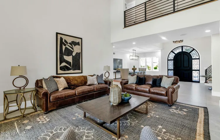 The main living room unfolds generously, inviting effortless everyday living and sophisticated entertaining in equal measure. Large-format porcelain flooring flows throughout, grounding the space while reflecting the abundant natural light that pours in from every angle.