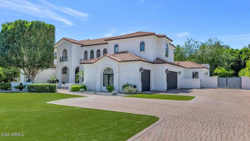 A second exterior perspective reveals the full footprint of this commanding residence, set back generously on its nearly acre irrigated lot. The scale of the home is apparent here — and so is the quality of its recent exterior refresh.