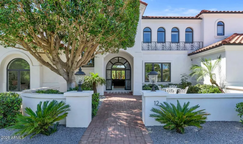 The entry approach sets a tone of understated grandeur — mature specimen plantings, a freshly painted facade, and arched architectural details that signal what awaits inside. First impressions here are lasting ones.