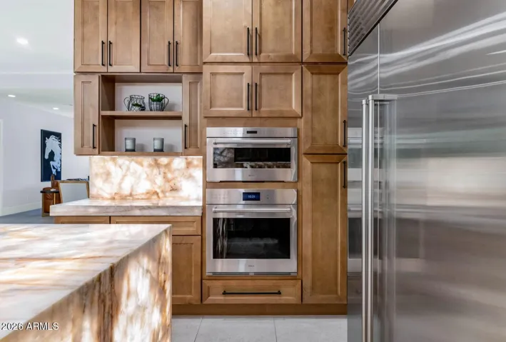 The appliance package here is simply without compromise. A Sub-Zero refrigerator and Wolf wall microwave and convection ovens are built seamlessly into floor-to-ceiling alder cabinetry with matte black hardware, creating a wall that is as functional as it is visually cohesive. This is a kitchen outfitted for the way people actually live.