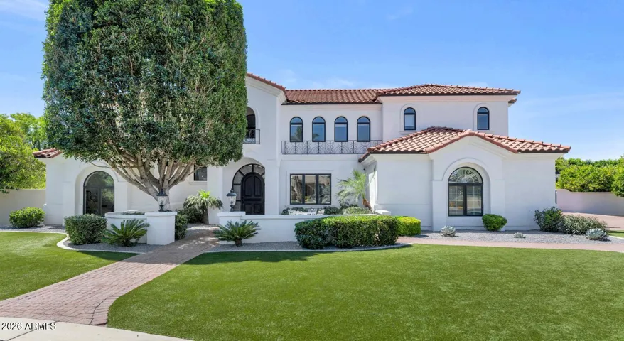 A commanding Mediterranean-inspired elevation sets the tone before you ever step inside. Warm stone detailing, a freshly painted facade, and mature landscaping frame a home that has been loved, invested in, and meticulously maintained. The wide motor court and lush lawn offer an arrival experience that feels both grand and genuinely welcoming.