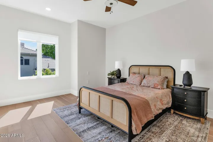This second-floor suite features warm hardwood flooring and an arched window that brings in soft natural light.