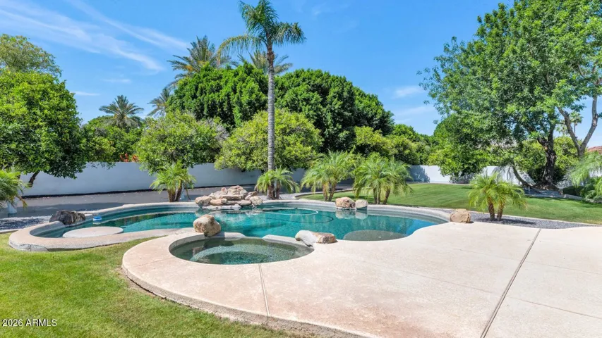 Pool, Spa, and Swim-Up Table
The pool is designed for living, not just looking. A spa, an in-pool dining table, and generous swim-up seating create an environment where afternoons stretch naturally into evenings. The surrounding lawn and mature landscaping complete a backyard that needs nothing added.
