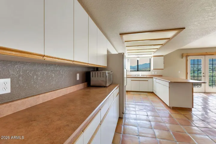 Hall into kitchen with additional countertop space and cabinets galore