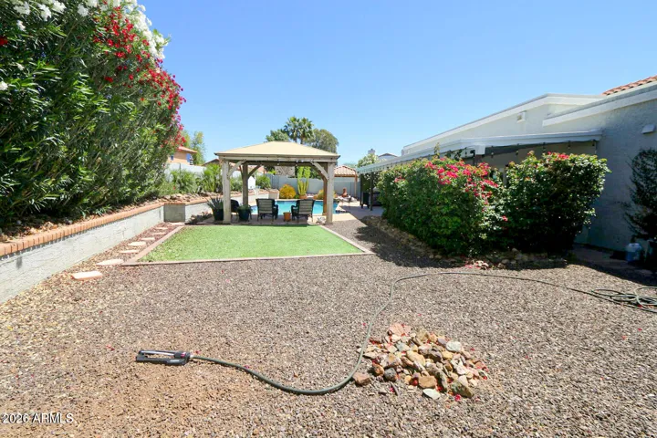 Turf grass with huge oleanders against the wall.