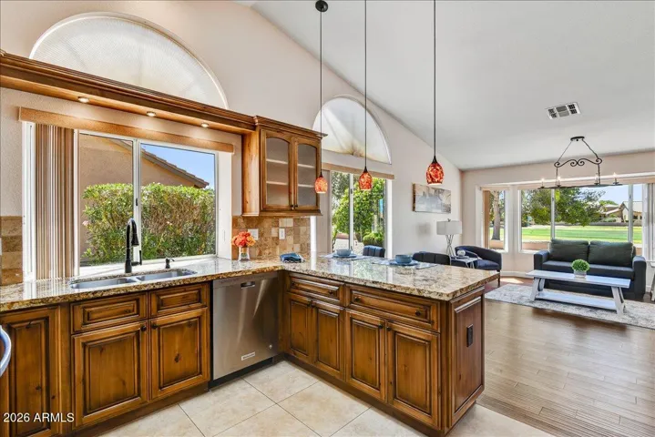 This chef’s kitchen features granite countertops, custom cabinets, high-quality appliances, and a breakfast bar for casual morning meals.