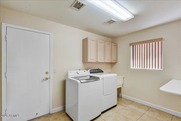 A functional laundry room with built-in cabinetry and extra storage, making organization effortless.