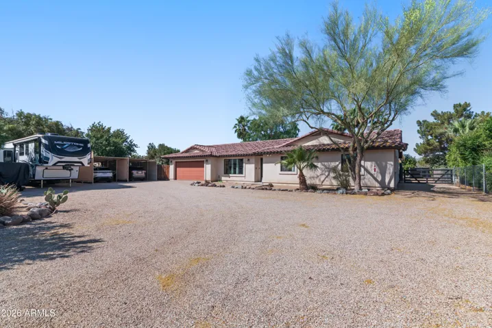 Oversized front parking area with 2 car garage, 2 car carport, RV parking, & RV gate to backyard