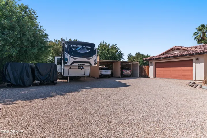 Oversized front parking area with 2 car garage, 2 car carport, & RV parking.