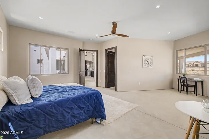 The oversized primary suite is a true retreat, offering generous square footage, mountain views, a sleek designer ceiling fan, and direct access to a spa-inspired ensuite.