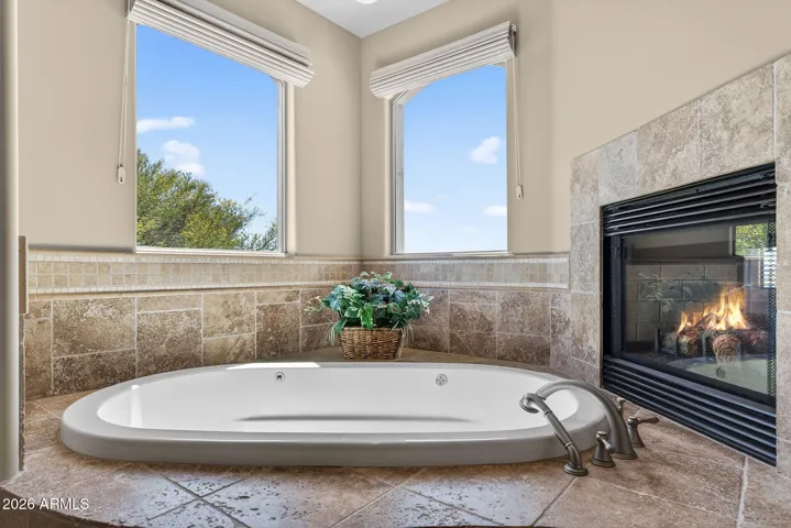 Nestled between the fireplace and wide windows bathing the space in light, this jetted tub may be the perfect place to relax
