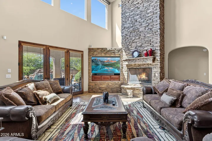 SOARING 20' Ceilings accent this floor to ceiling stone faced fireplace