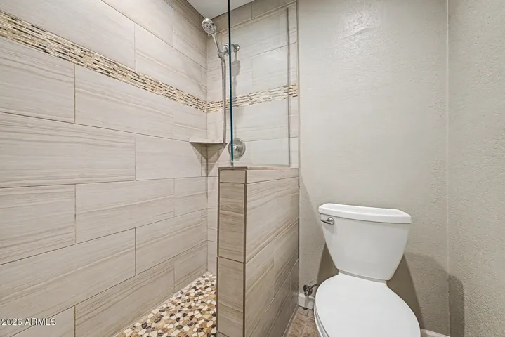 Custom Walk-In Shower with Upgraded Tile, Stone, and Glass Enclosure.