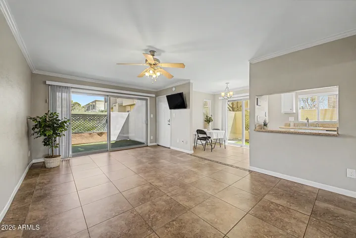 Spacious Family Room with Upgraded Tile Flooring, Crown Molding, Ceiling Fan, Vertical Blinds, Updated Patio Slider Door, Flat Screen TV.