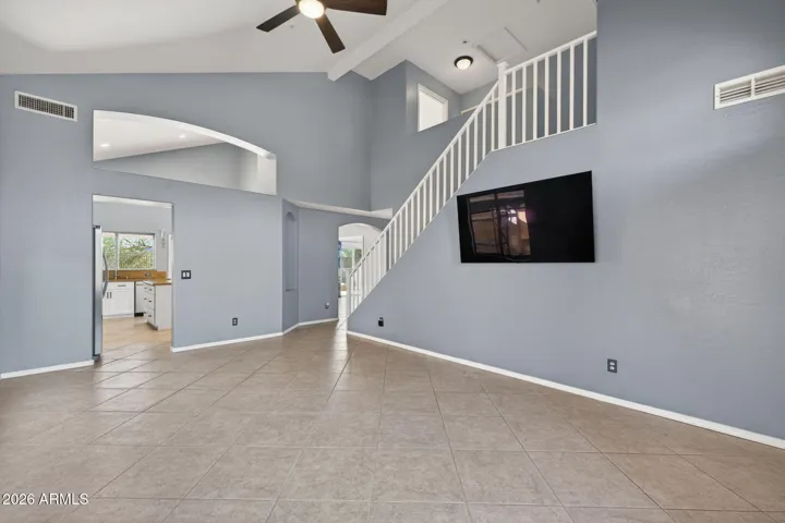 Neutral tones, tiled floors, and architectural cutouts provide a modern aesthetic with versatile layout options.