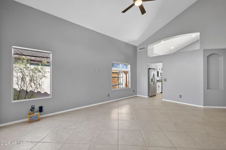 Soaring ceilings, neutral tile floors, and large windows create an open, airy feel perfect for entertaining.