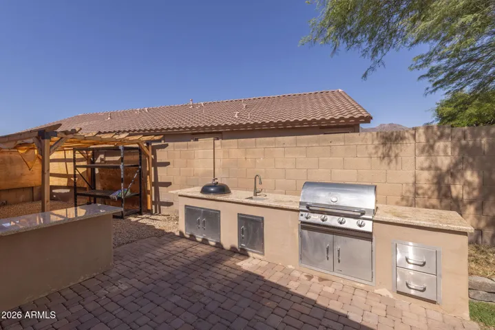 Entertain in style with this custom outdoor kitchen featuring both a propane gas grill and a charcoal grill for the ultimate gourmet cooking experience.