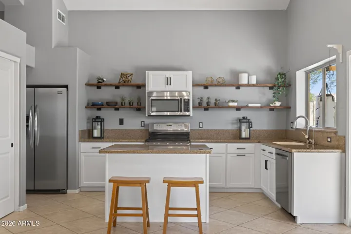Rustic wood shelving balances the recently refaced kitchen cabinetry.