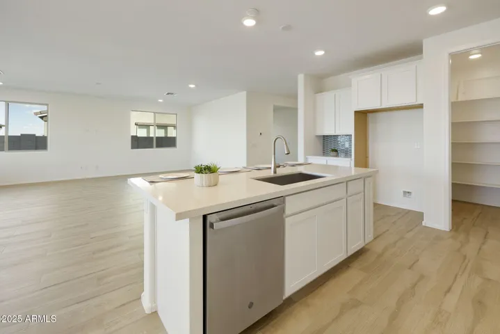GOURMET KITCHEN WITH PAINTED CABINETS, QUARTZ COUNTERS, DESIGNER BACKSPLASH, GAS COOKTOP, BUILT-IN OVENS AND DESIGNER HOOD.