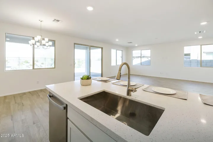LARGE ISLAND OPEN TO THE GREATY ROOM WITH QUARTZ COUNTERS AND SINGLE BOWL SINKS.