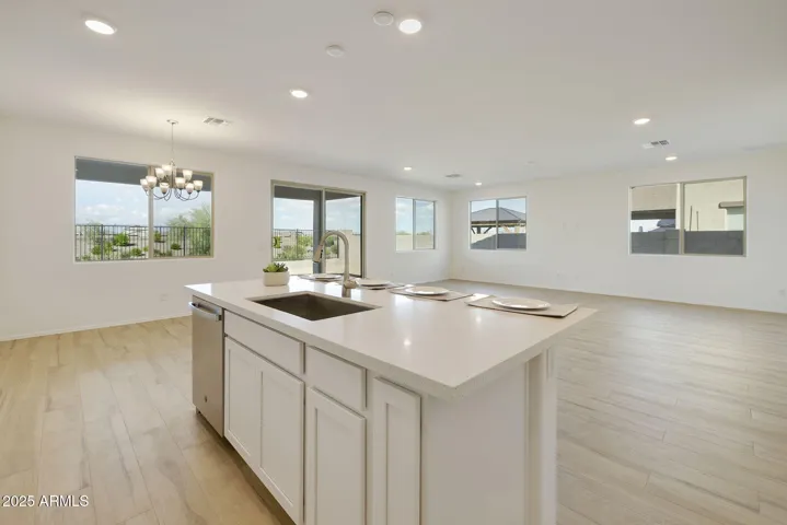 GOURMET KITCHEN WITH PAINTED CABINETS, QUARTZ COUNTERS, DESIGNER BACKSPLASH, GAS COOKTOP, BUILT-IN OVENS AND DESIGNER HOOD.