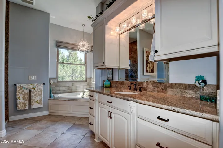 Her vanity with spacious counterspace and cabinets. The lighting is truly a focal point
