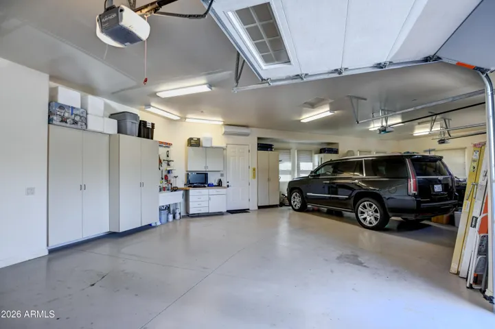 Painted floors,Built in Cabinets have ample storage space for organization, double sink, tool bench and door that leads to the side yard