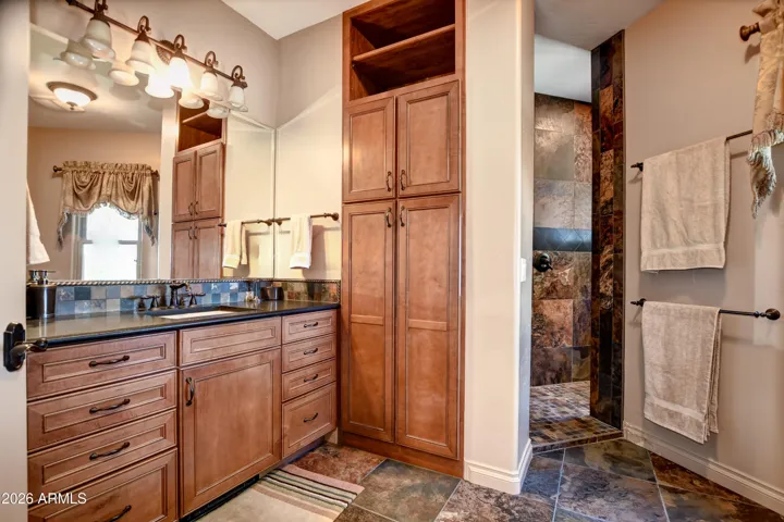 Natural Stone Tile Slate Floors, Pecan Cabinetry, Soapstone countertops, built in linen closet and shelving to complete this ensuite