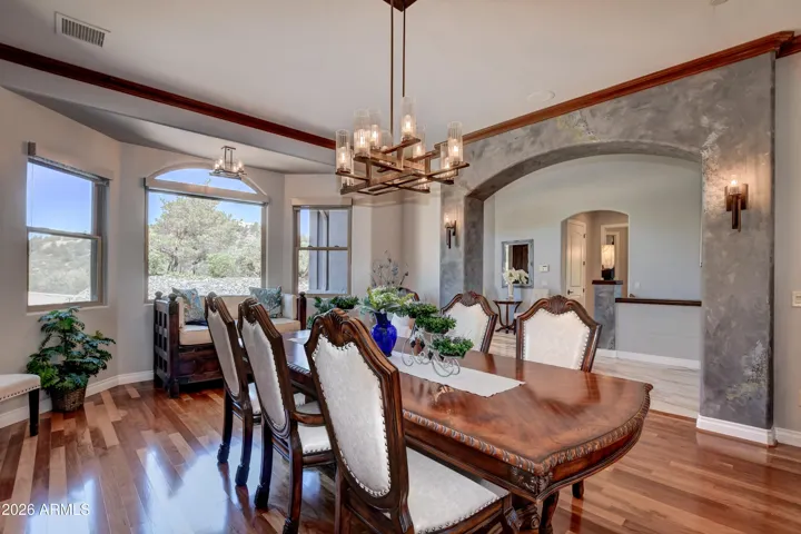 The archway is accented with custom plaster and colored accents adorned with wall sconces for elegance