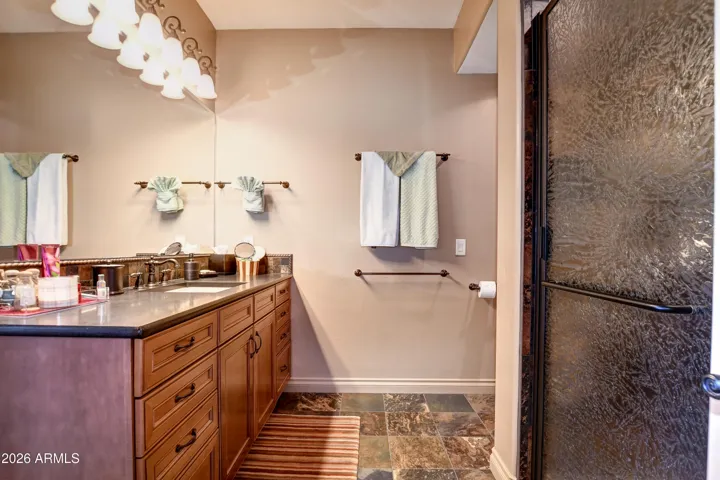 Attached to the bedroom, large expansive vanity and natural stone slate tile flooring