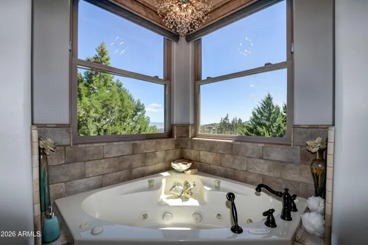 Corner windows, crystal chandelier, perfectly outline this jetted tub for that spa like experience