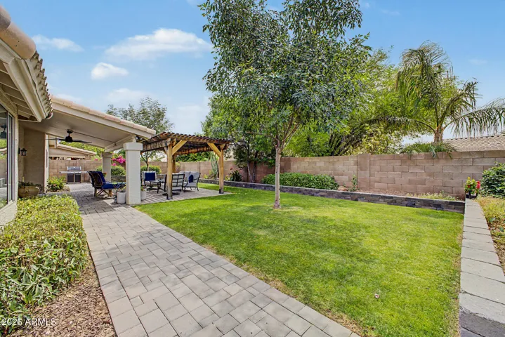 Paver walkway along the side of the home leads side yard and access to the garage side entry and gate.